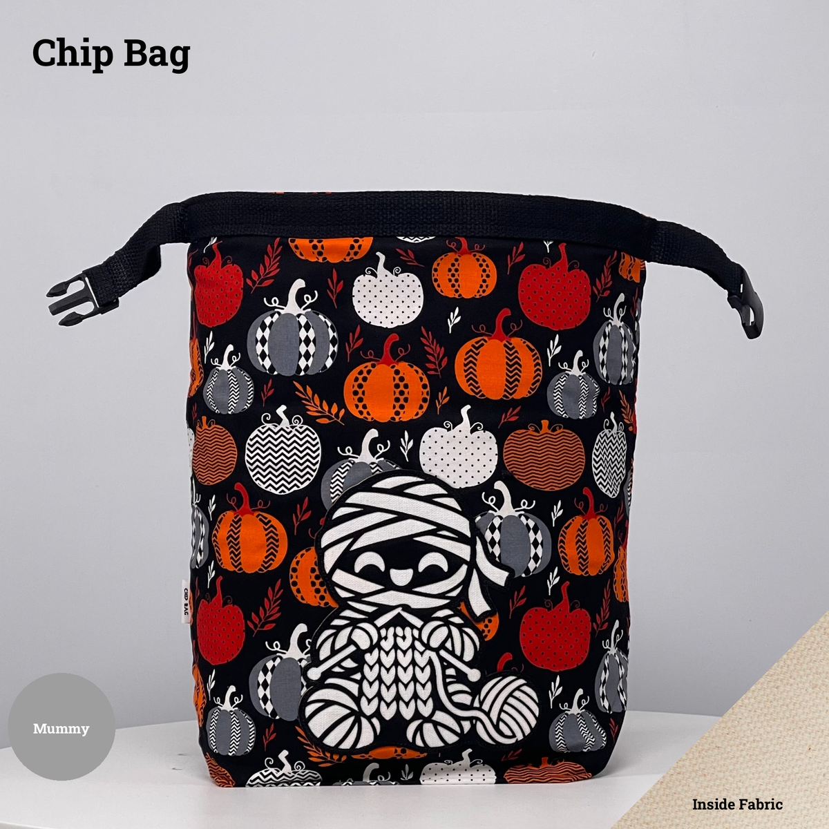Black pumpkin-print Chip Bag featuring a mummy appliqué knitting beside a ball of yarn.